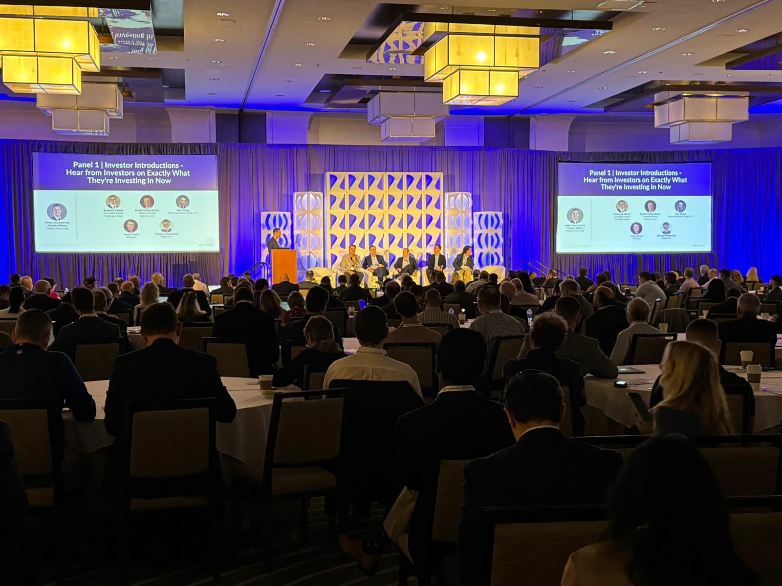 Family Office Club investor panel on stage in front of a full ballroom